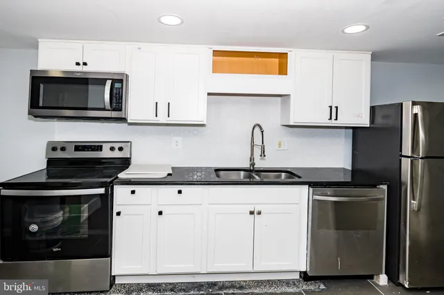 a kitchen with stainless steel appliances granite countertop a stove a sink and a refrigerator
