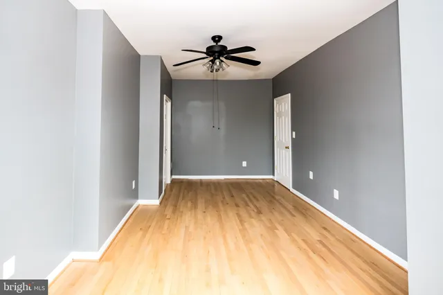 a view of a room with wooden floor and ceiling fan