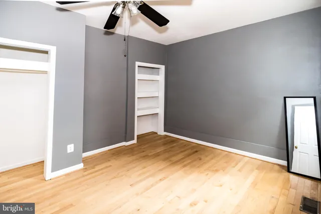 a view of empty room with wooden floor