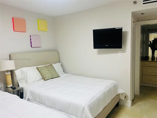 a bedroom with a bed and a flat screen tv