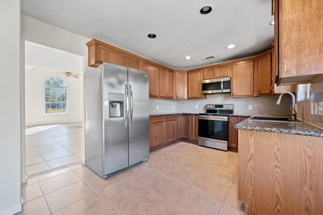 a kitchen with stainless steel appliances granite countertop a refrigerator sink and cabinets