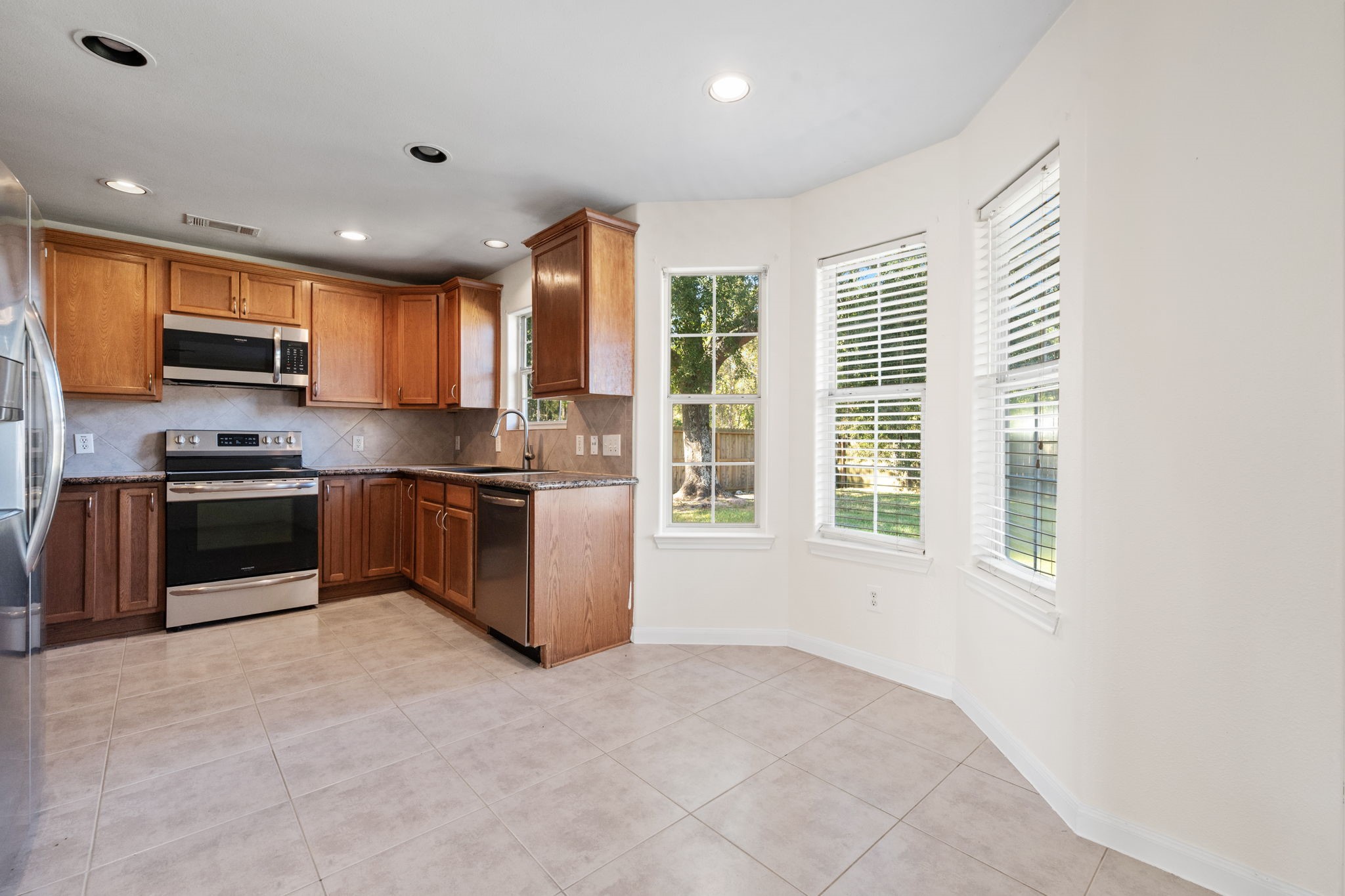 25785 Hickory Lane Splendora, TX 77372 - Photo 15 of 28 a kitchen with stainless steel appliances granite countertop a stove a sink and a refrigerator