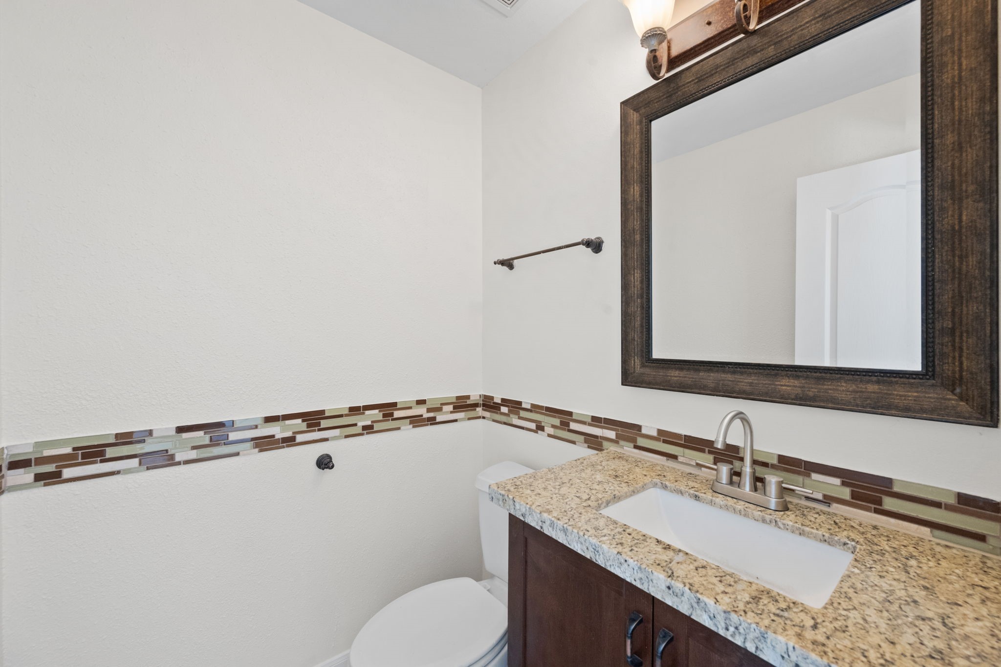 25785 Hickory Lane Splendora, TX 77372 - Photo 16 of 28 a bathroom with a granite countertop sink a toilet and mirror