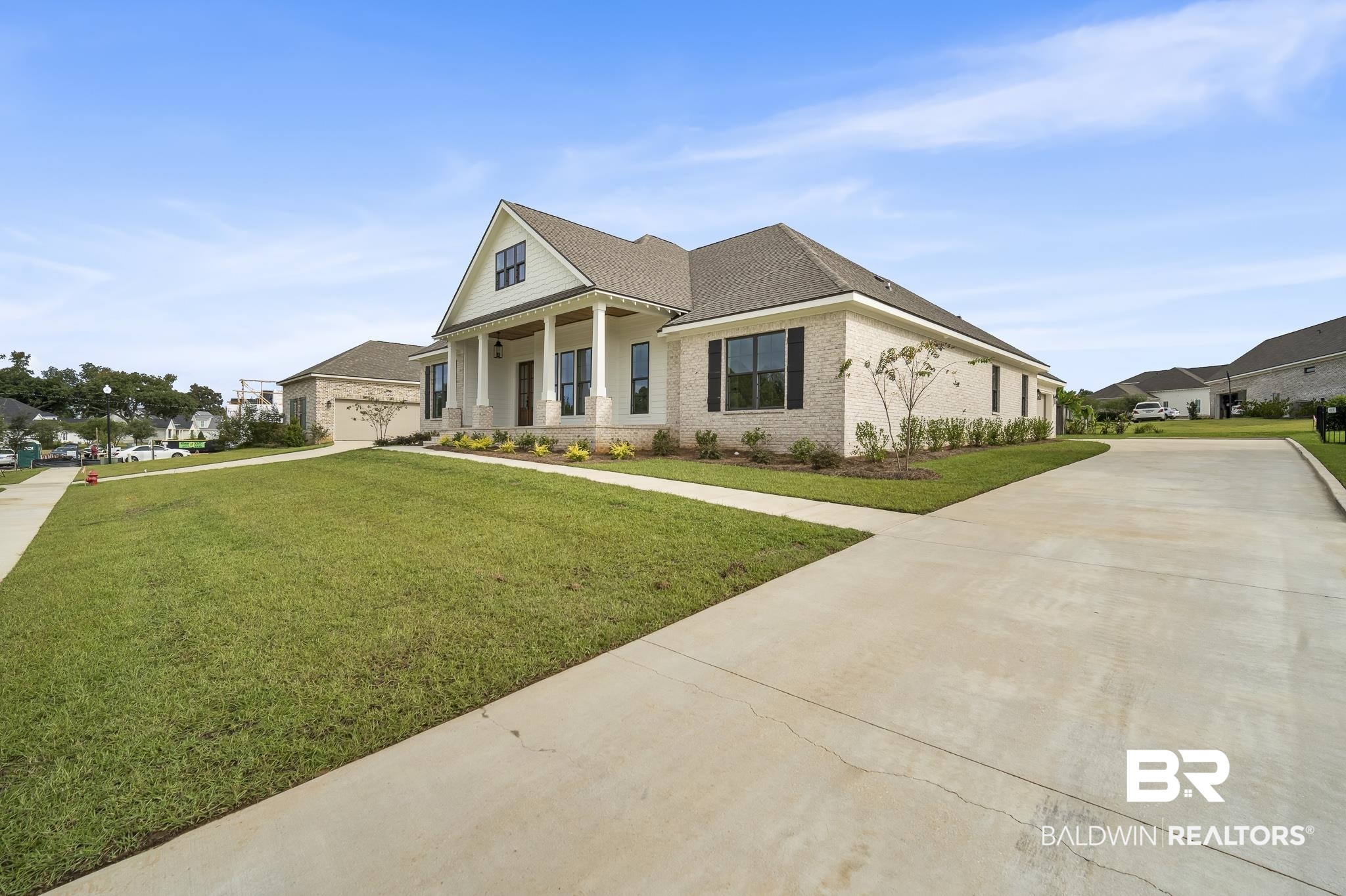21826 Veranda Boulevard Fairhope, AL 36532 - Photo 3 of 42 View of front of home with a porch, a front yard, driveway, brick siding, and roof with shingles