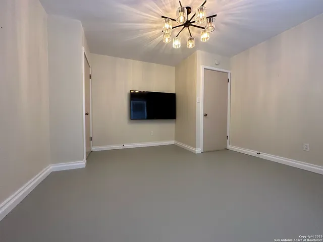 an empty room with windows and ceiling fan
