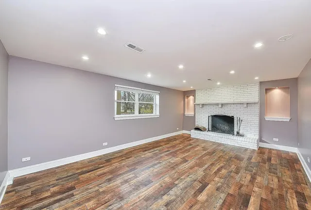 a view of empty room with a fireplace and fan