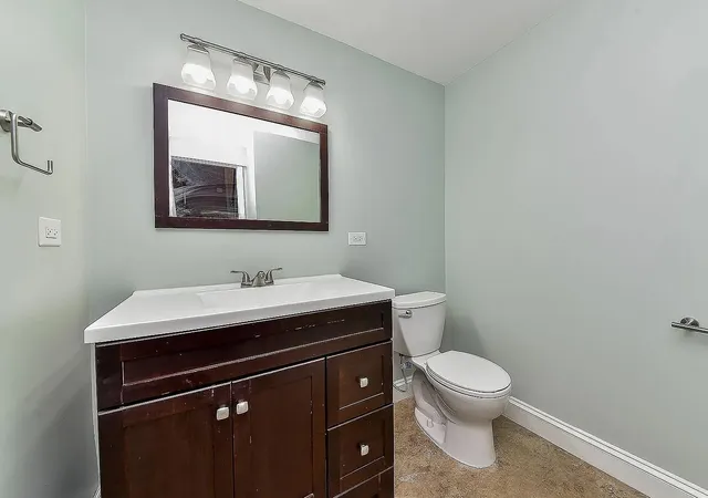 a bathroom with a toilet sink and mirror