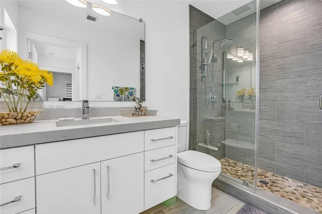 a bathroom with a double vanity sink toilet and shower