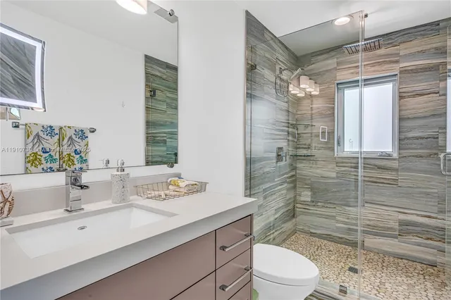 a bathroom with a sink a toilet and shower