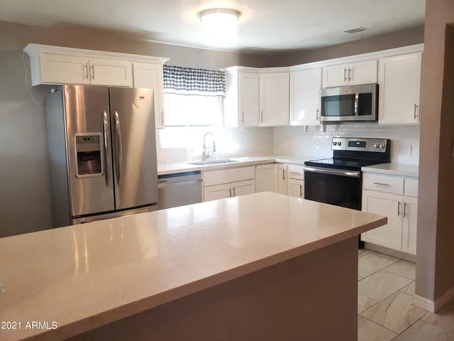 a kitchen with stainless steel appliances a refrigerator stove microwave and sink