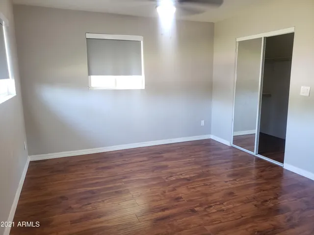 an empty room with wooden floor and closet