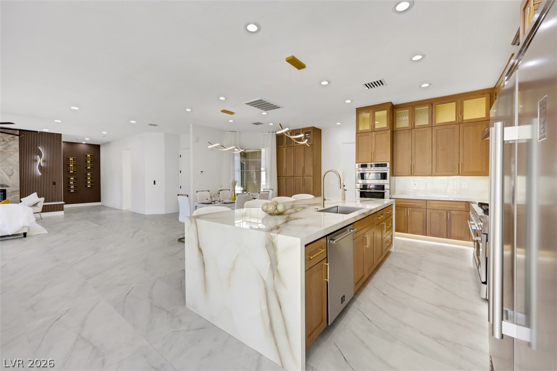 5015 Rivedro Street Las Vegas, NV 89135 - Photo 34 of 91 Marble-clad island kitchen with integrated appliances, perfect for entertaining.