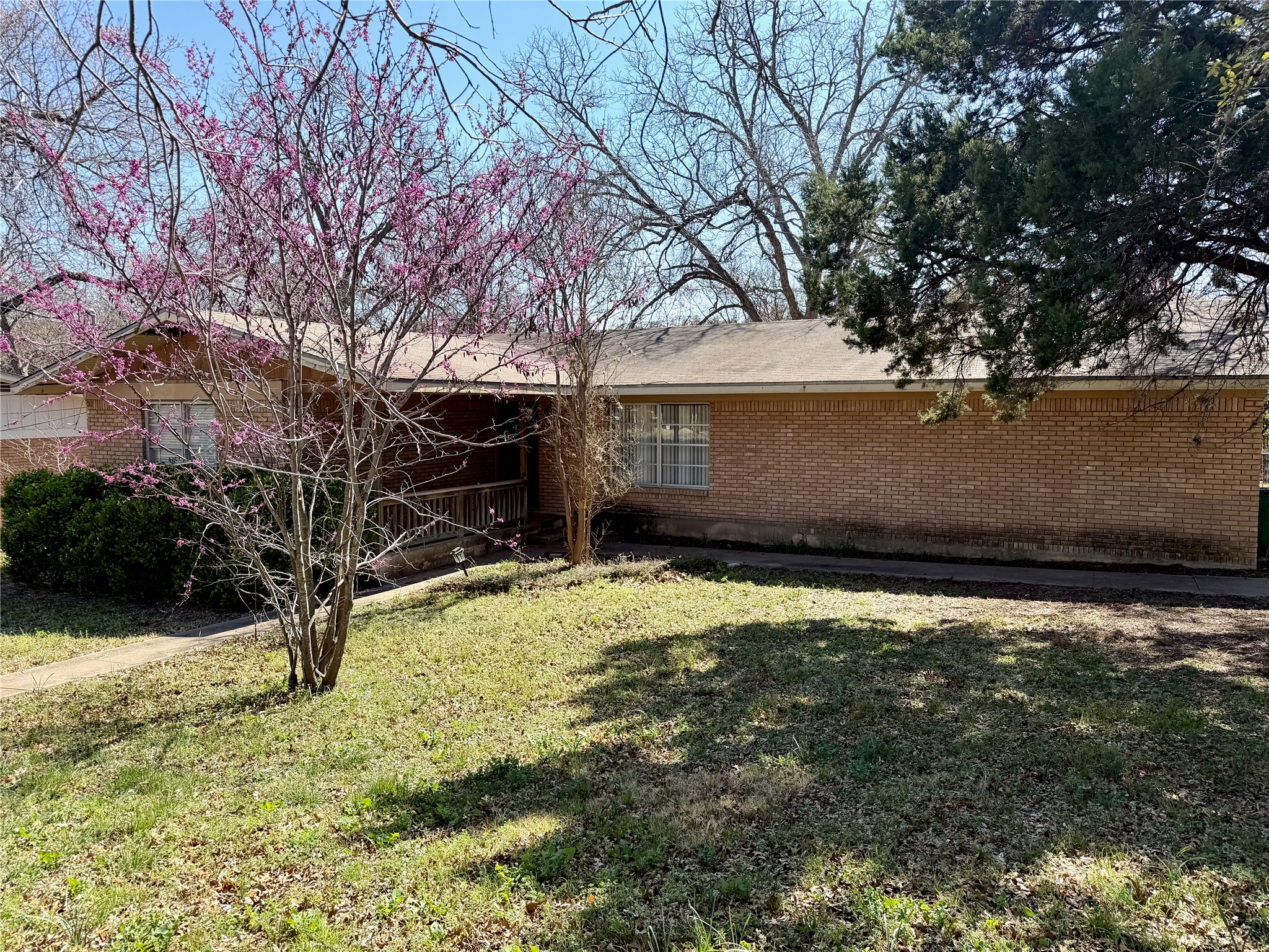 Brick ranch house on corner lot with large front yard.
