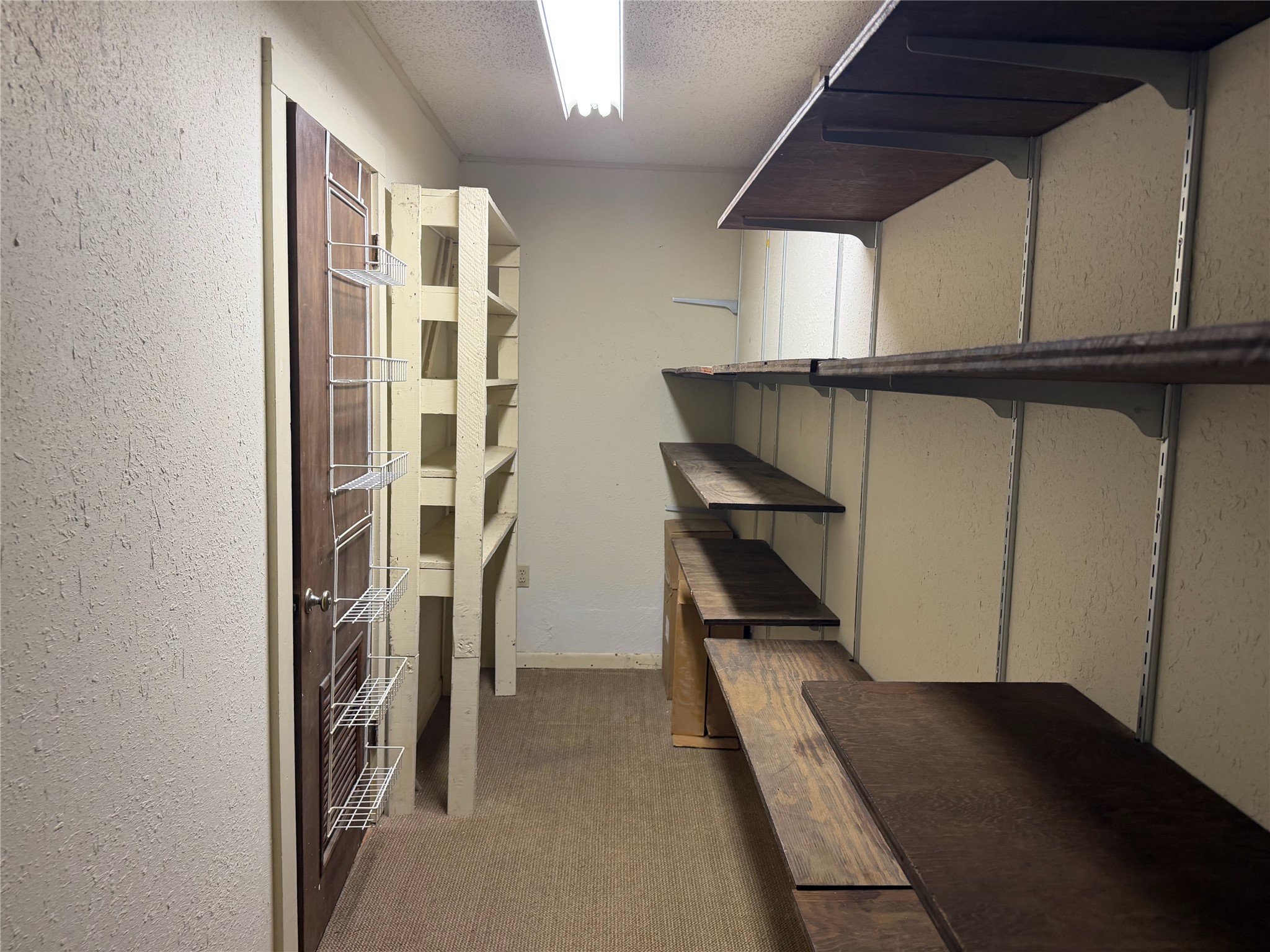 305 West Caddo Street Austin, TX 78753 - Photo 12 of 13 Storage room behind the built in bookshelves. Door leads to laundry room, which might give the option to create a new primary suite with bath here.