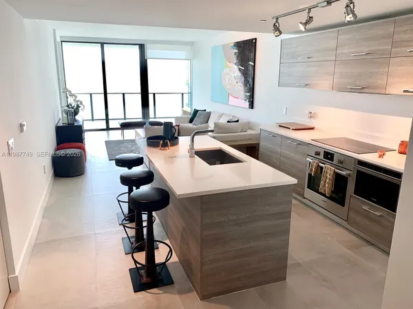 a kitchen with a stove a counter space a sink and a window