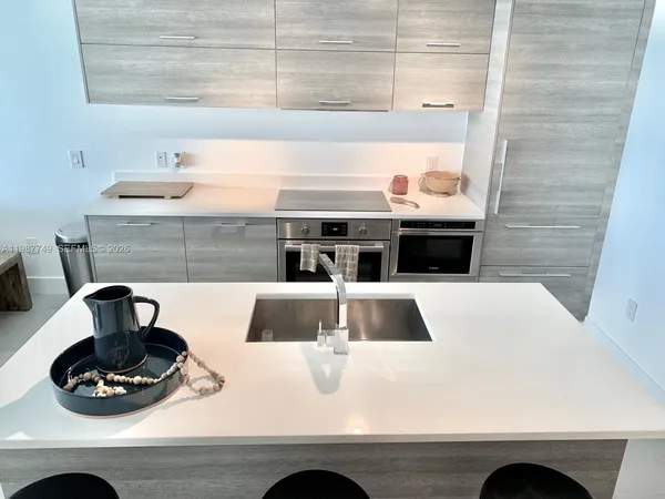 a kitchen with a stove and wooden floor