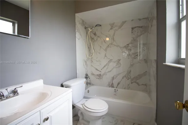 a white toilet sitting next to a bath tub