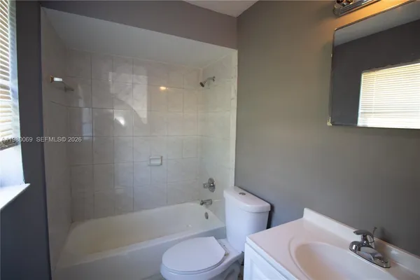 a bathroom with a bathtub toilet sink vanity and mirror