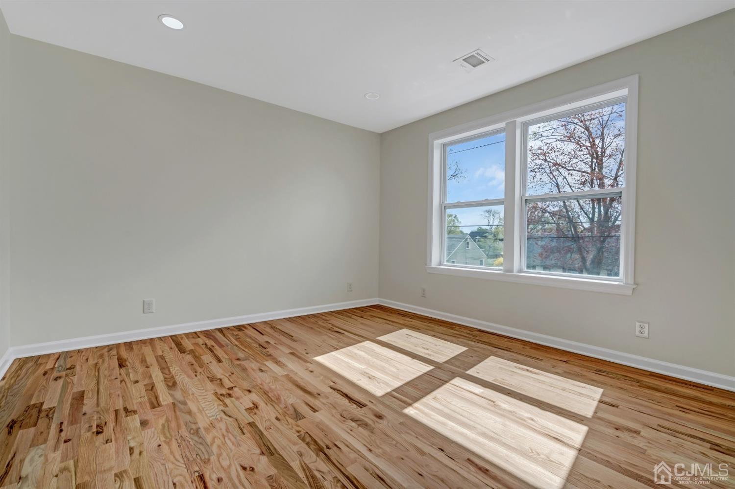22 Stiles Road Edison, NJ 08817 - Photo 24 of 48 a view of an empty room with wooden floor and a window