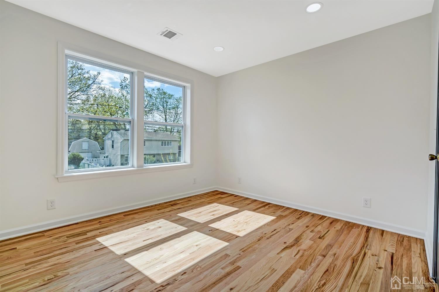 22 Stiles Road Edison, NJ 08817 - Photo 28 of 48 a view of an empty room with wooden floor and a window
