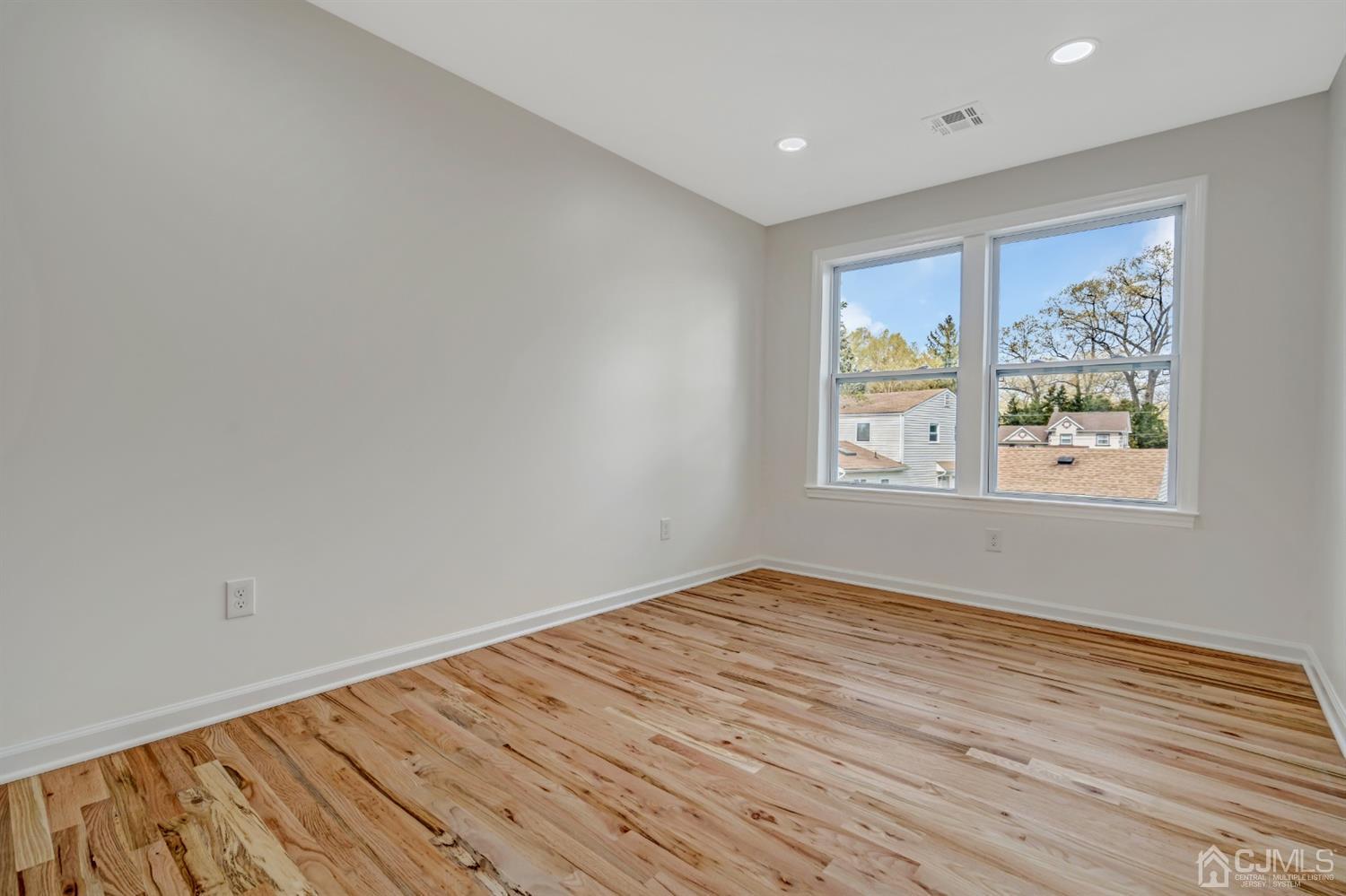 22 Stiles Road Edison, NJ 08817 - Photo 29 of 48 a view of an empty room with wooden floor and a window