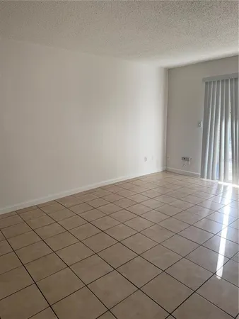a kitchen with white cabinets and a refrigerator