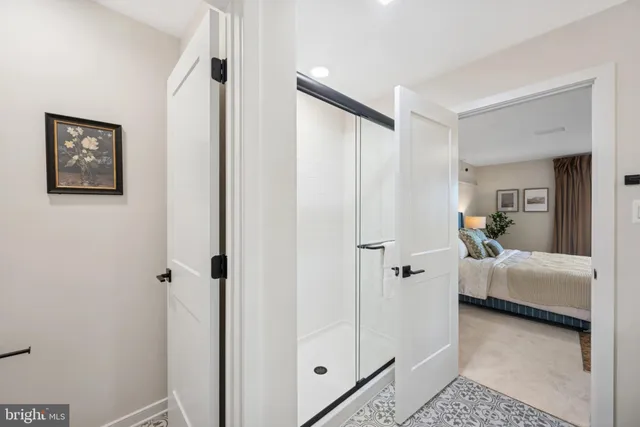 a bathroom with a tub shower and hardwood floor