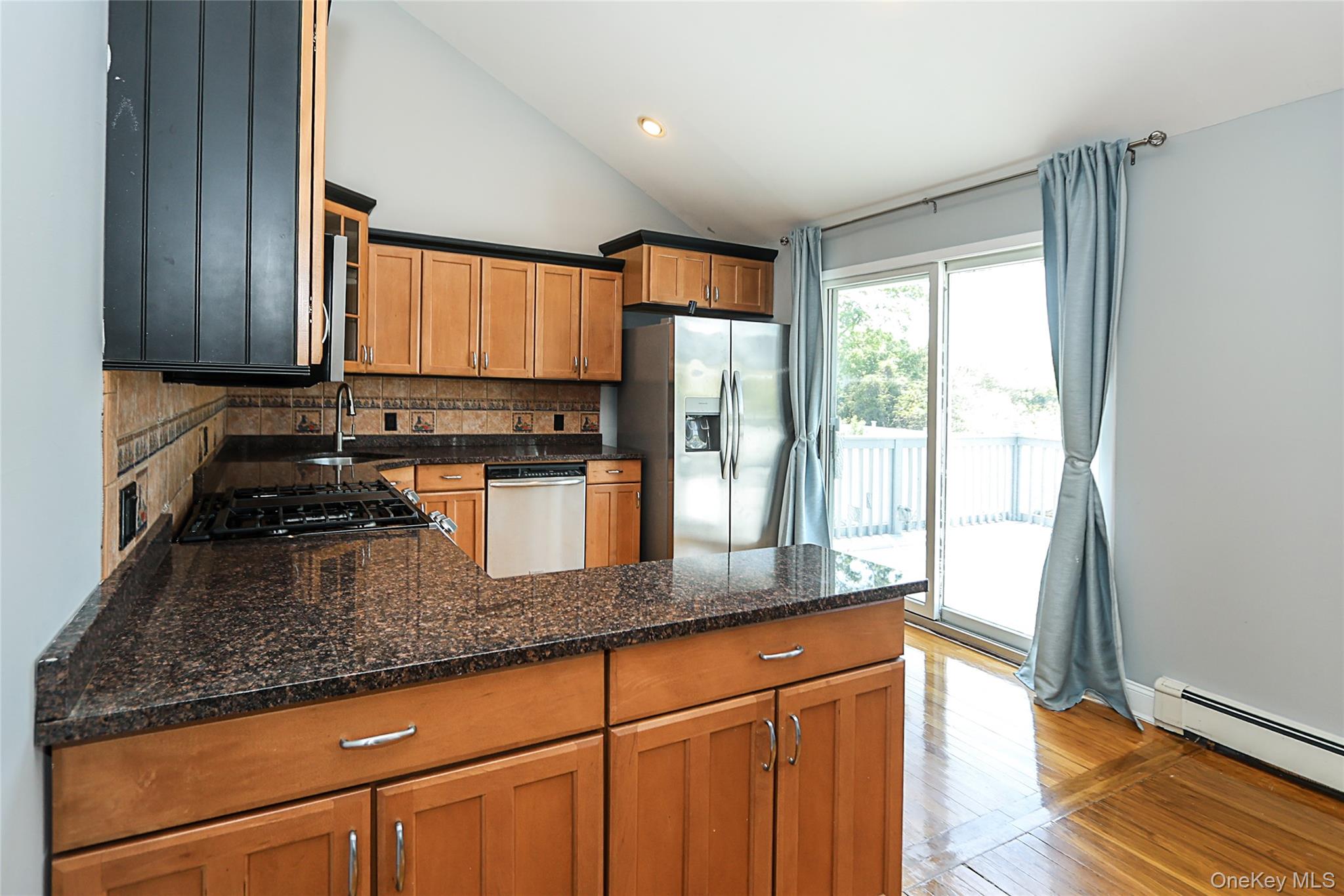 874 Seamans Nck Road Wantagh, NY 11793 - Photo 16 of 39 a kitchen with granite countertop a refrigerator a sink and wooden cabinets