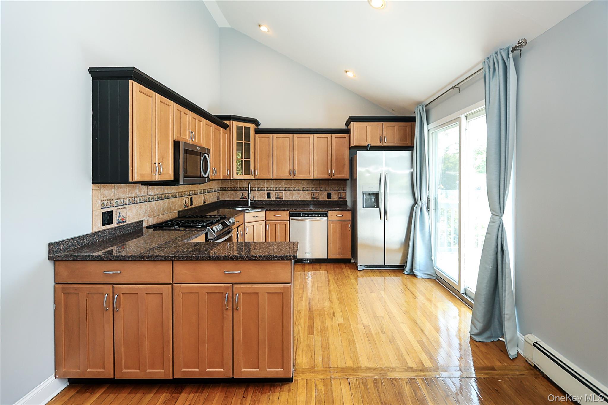 874 Seamans Nck Road Wantagh, NY 11793 - Photo 17 of 39 a kitchen with stainless steel appliances granite countertop a stove a sink and a refrigerator