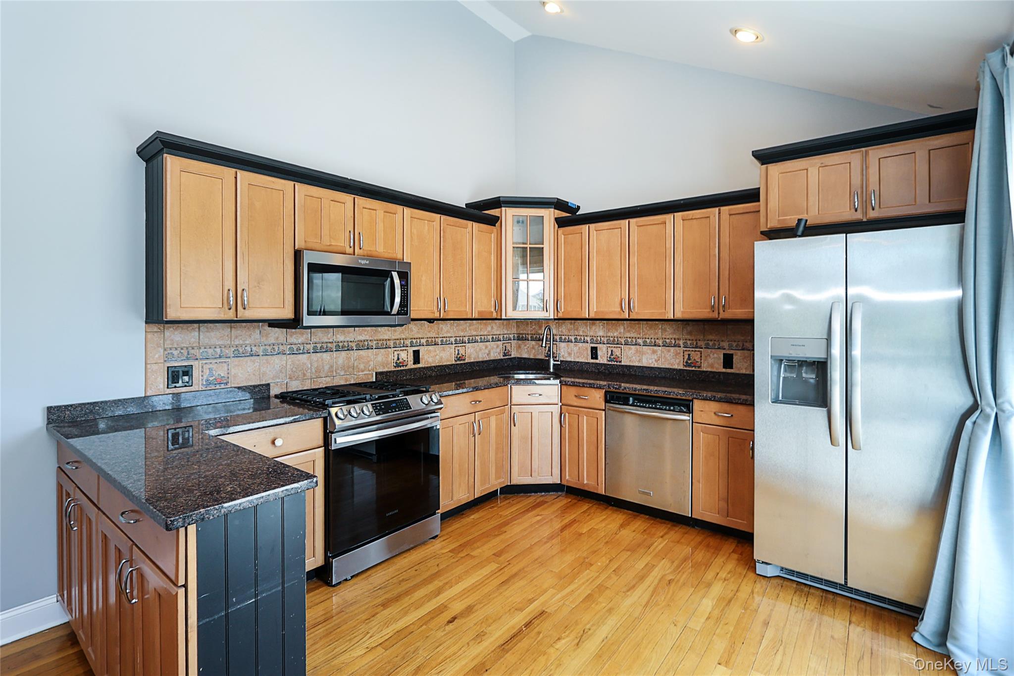 874 Seamans Nck Road Wantagh, NY 11793 - Photo 18 of 39 a kitchen with granite countertop wooden floors stainless steel appliances a sink and a window