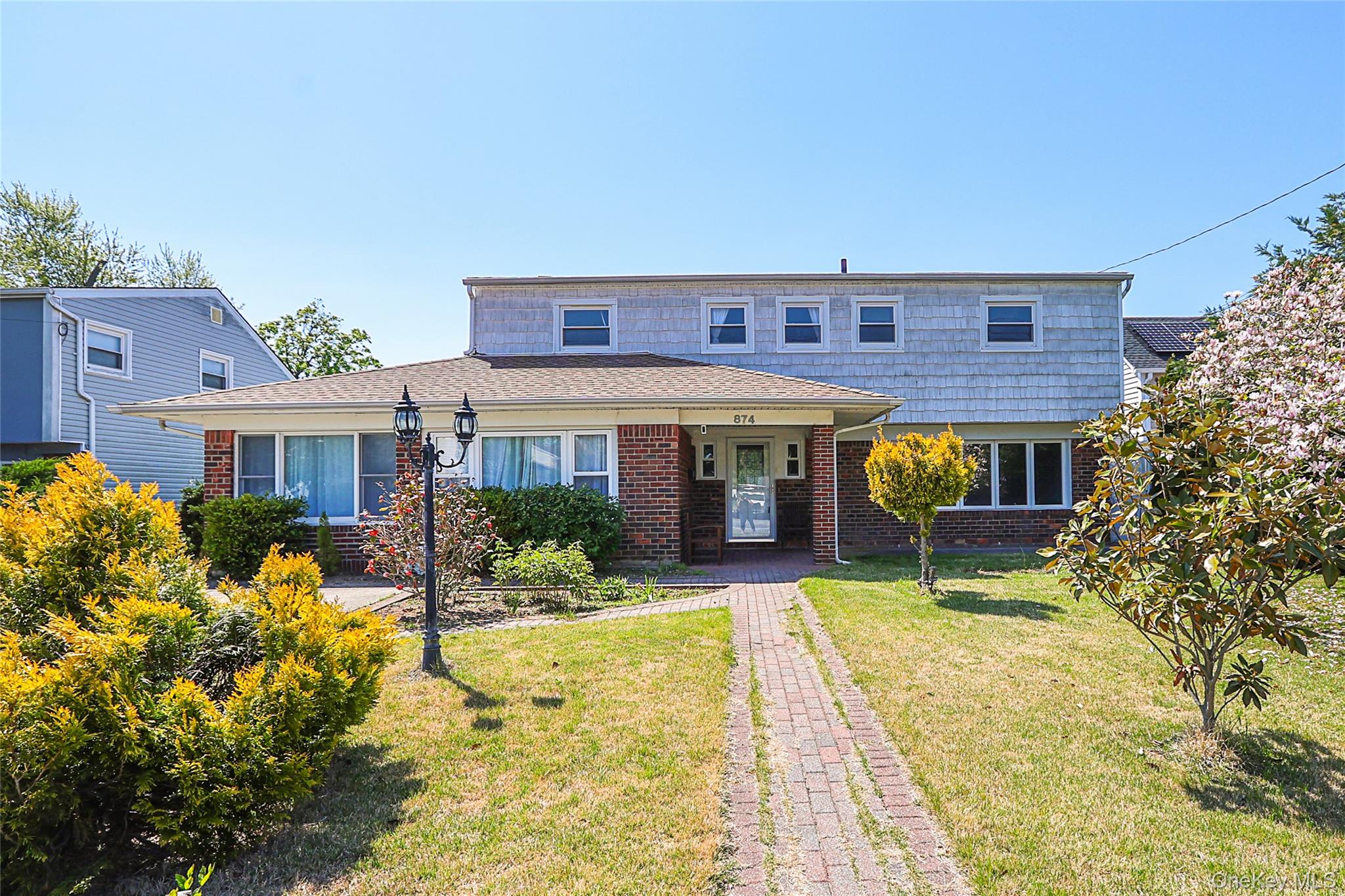 874 Seamans Nck Road Wantagh, NY 11793 - Photo 2 of 39 front view of a brick house with a yard