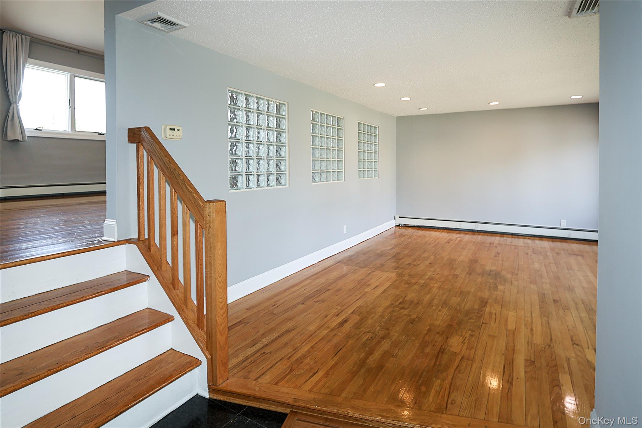 874 Seamans Nck Road Wantagh, NY 11793 - Photo 5 of 39 a view of an empty room with wooden floor and stairs
