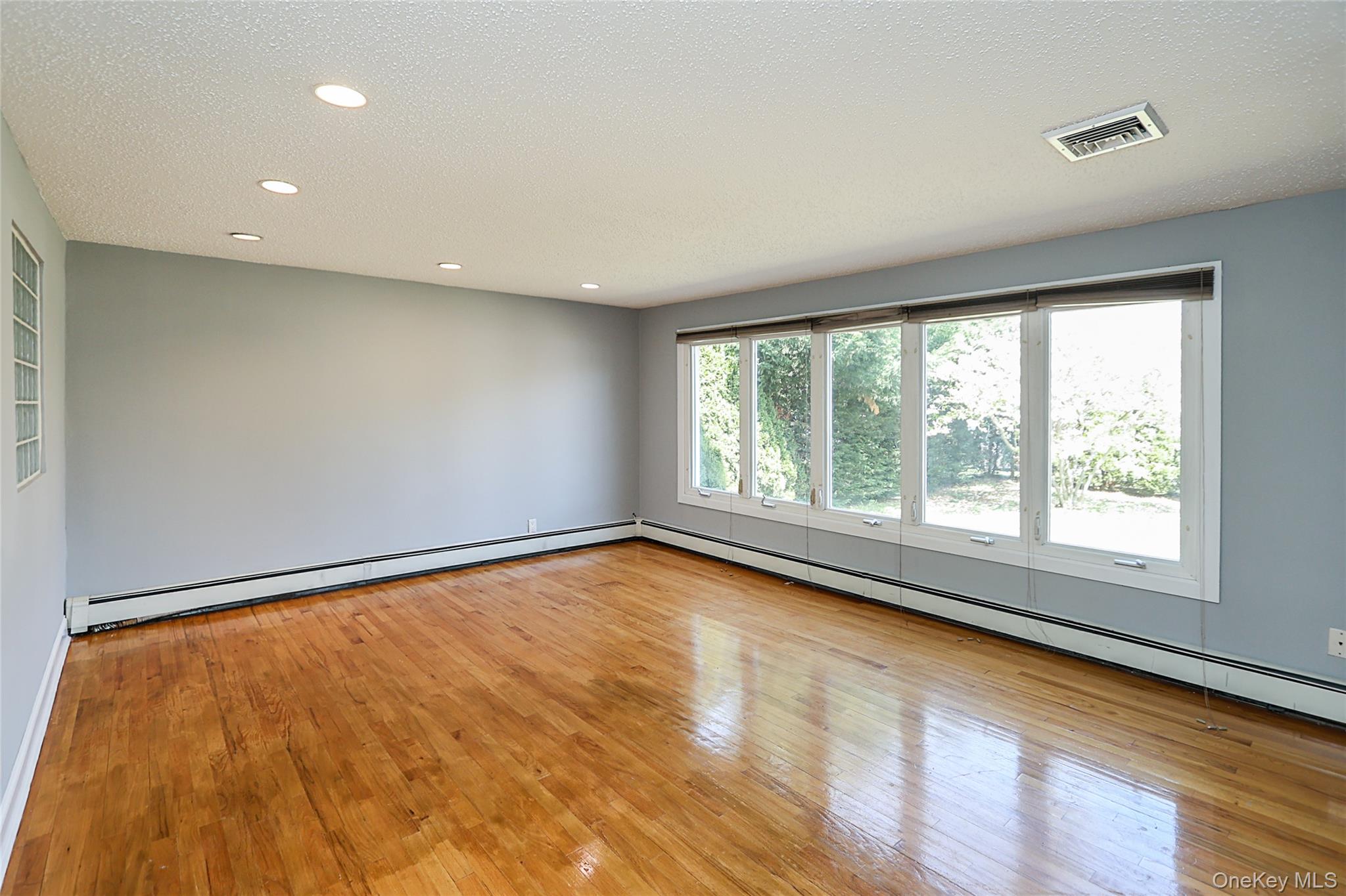 874 Seamans Nck Road Wantagh, NY 11793 - Photo 6 of 39 a view of an empty room with a window and wooden floor