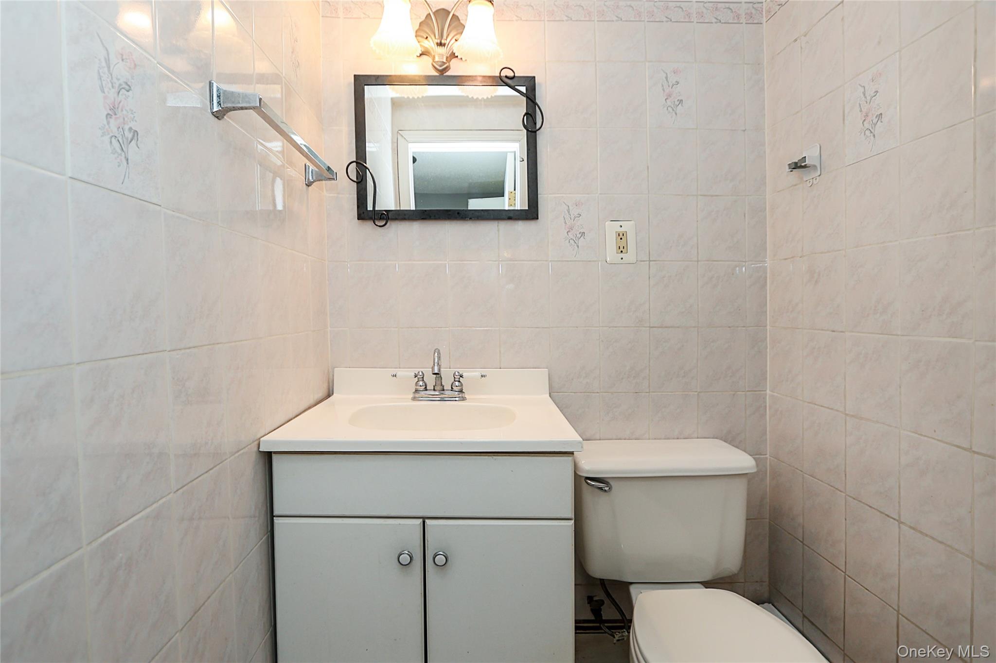 874 Seamans Nck Road Wantagh, NY 11793 - Photo 9 of 39 a bathroom with a toilet sink and mirror