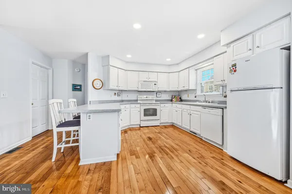 a kitchen with white cabinets and white appliances