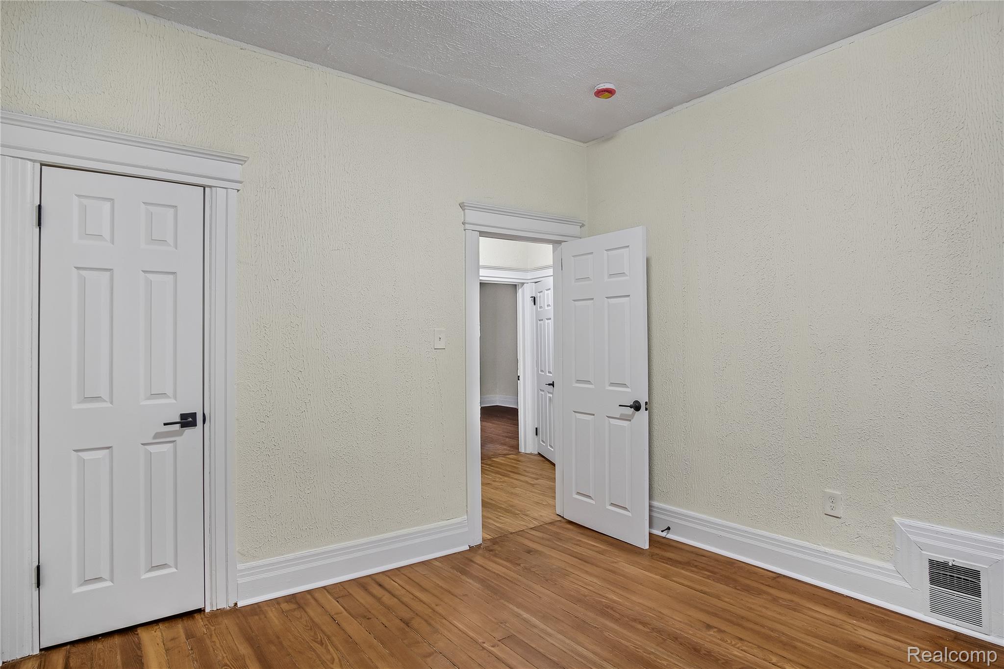 427 Melbourne Street Detroit, MI 48202 - Photo 14 of 29 Unfurnished bedroom with wood-type flooring and a textured wall