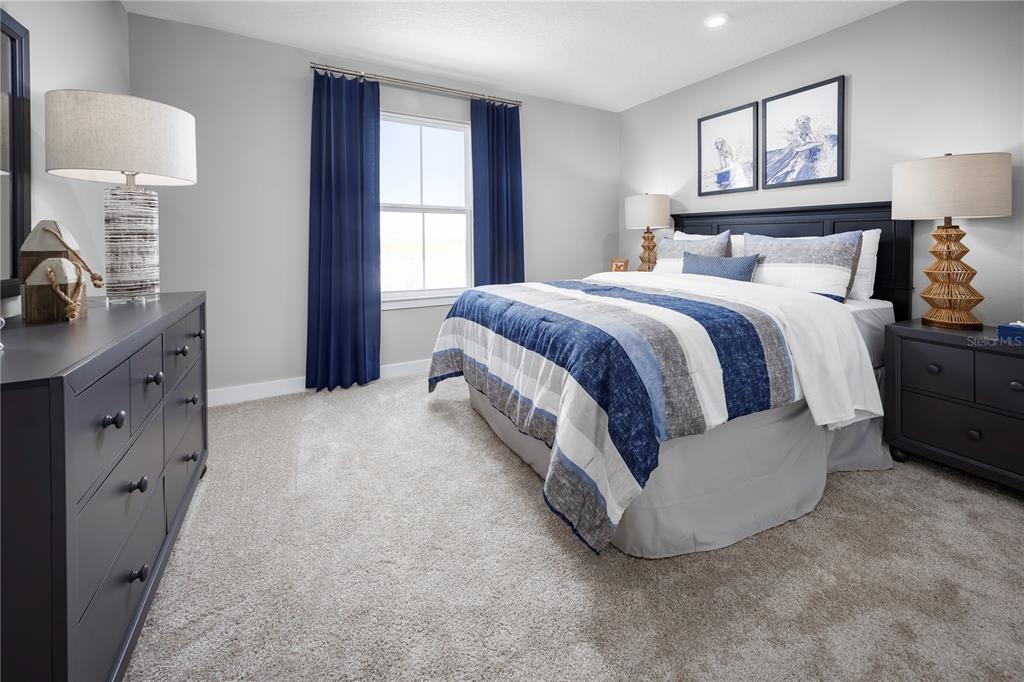 22177 Pine Grove Loop Leesburg, FL 34748 - Photo 11 of 15 a spacious bedroom with a bed and a lamp