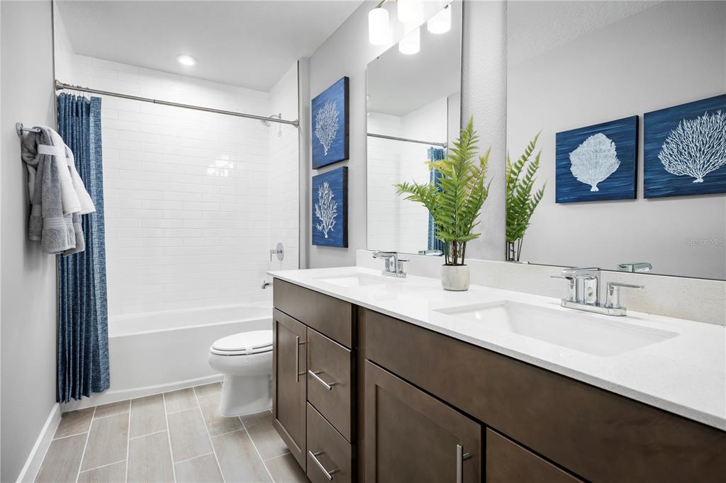 22177 Pine Grove Loop Leesburg, FL 34748 - Photo 14 of 15 a bathroom with a double vanity sink toilet mirror and shower