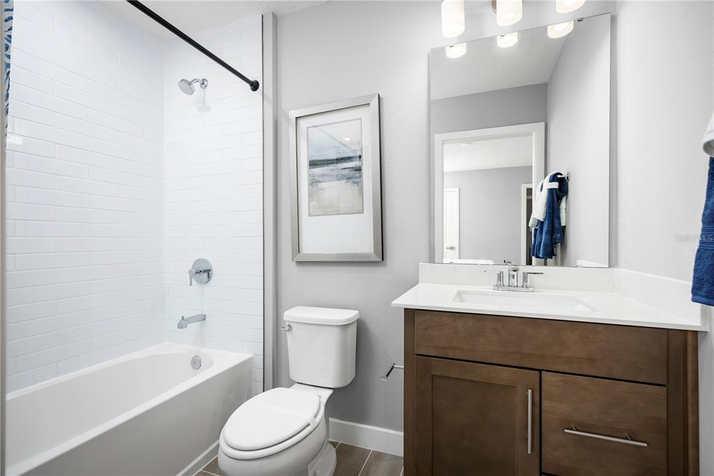22177 Pine Grove Loop Leesburg, FL 34748 - Photo 15 of 15 a bathroom with a sink a toilet a mirror a vanity and shower