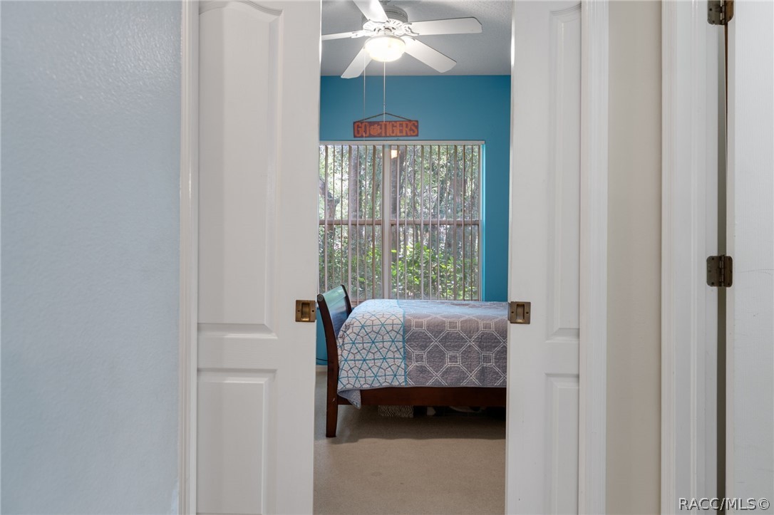 2460 West Pine Ridge Boulevard Beverly Hills, FL 34465 - Photo 27 of 47 a bedroom with a bed and a chandelier