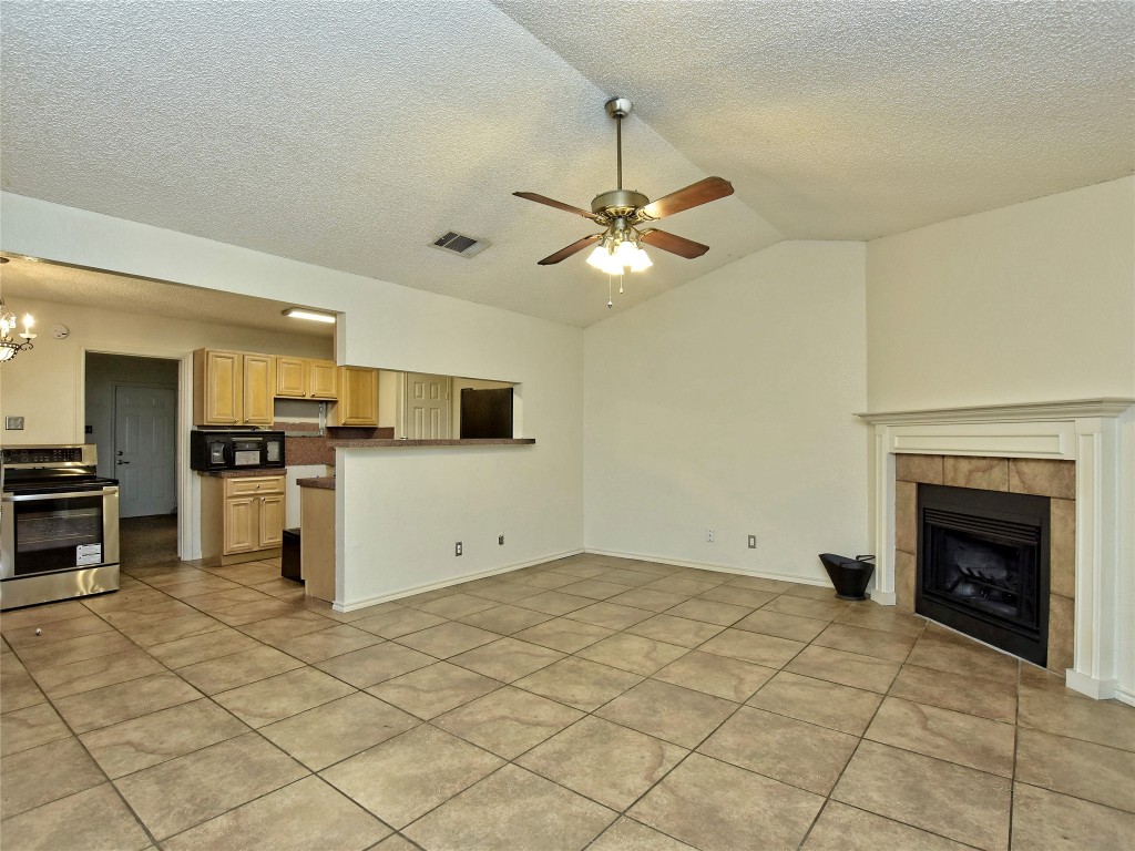 415 Fantail Loop, Unit B Austin, TX 78734 - Photo 3 of 10 a view of a kitchen with microwave and a stove top oven