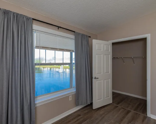 a view of a room with wooden floor and a bathroom