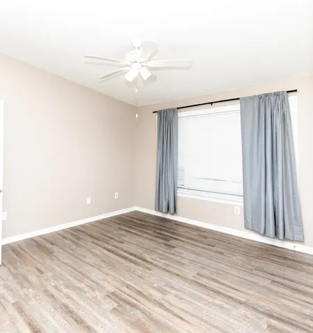 a view of a room with wooden floor and a window