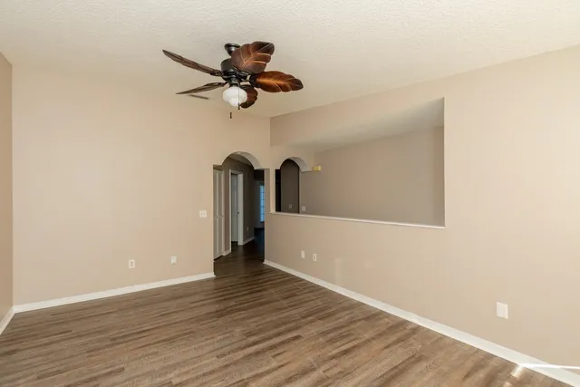 a view of a room with wooden floor and ceiling fan