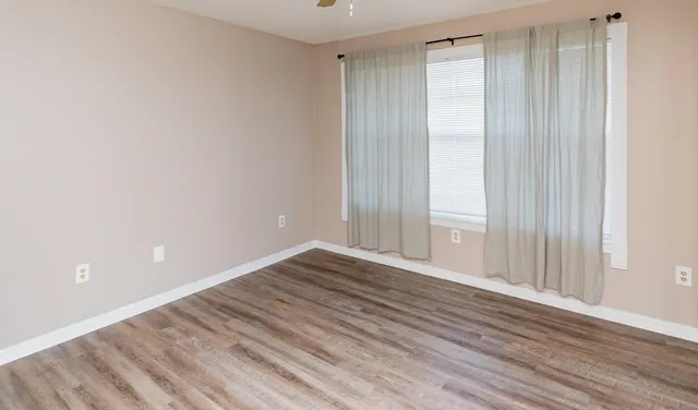 a view of an empty room with wooden floor