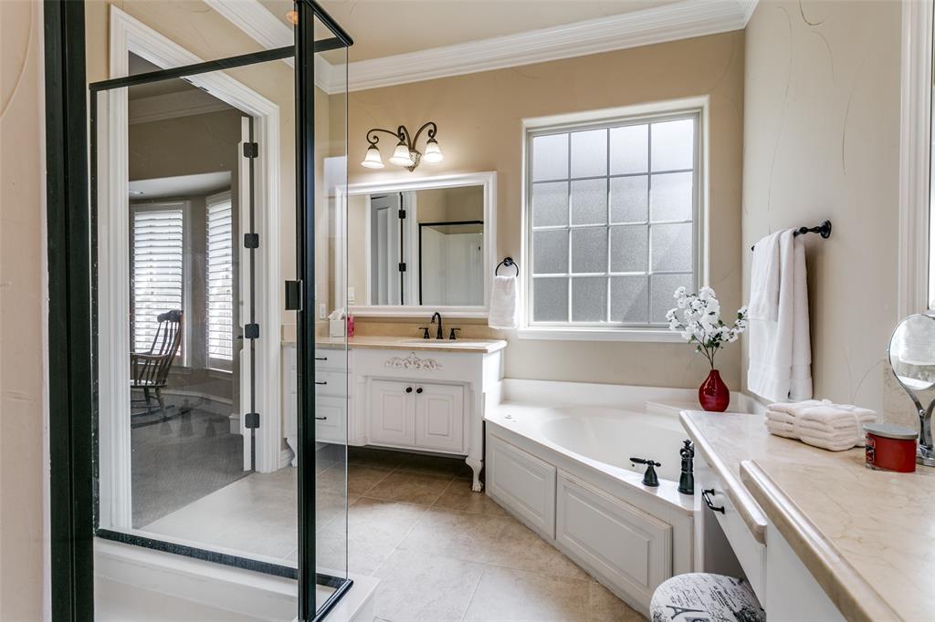 800 Rockingham Drive Irving, TX 75063 - Photo 27 of 35 a bathroom with a tub sink double vanity and a shower