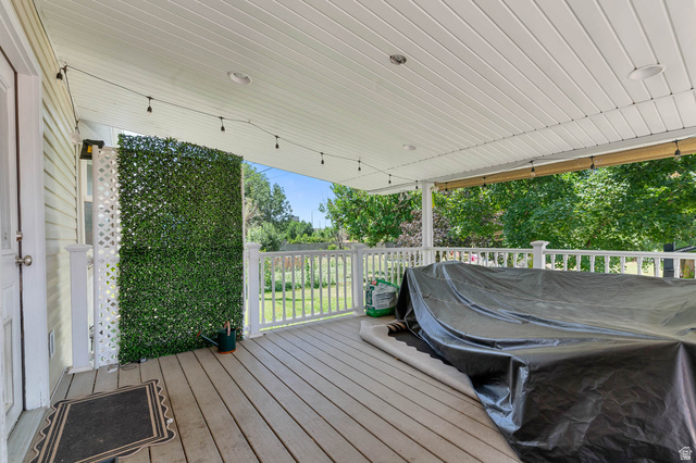 1489 North 400 West Bountiful, UT 84010 - Photo 39 of 47 Covered outdoor deck with light wood-finish flooring, white railing, and a white beadboard ceiling featuring recessed lighting