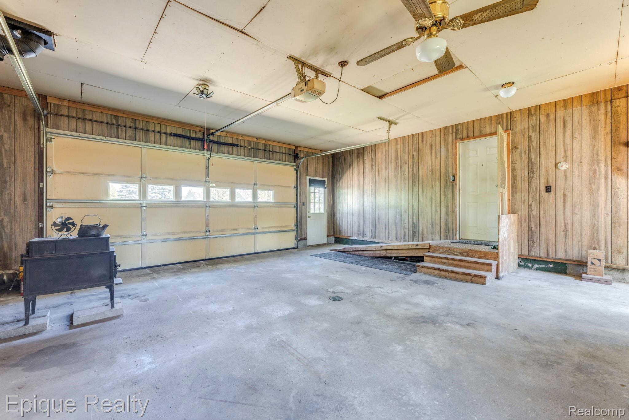 11110 Davison Road Davison, MI 48423 - Photo 51 of 65 Garage featuring a garage door opener and wood walls