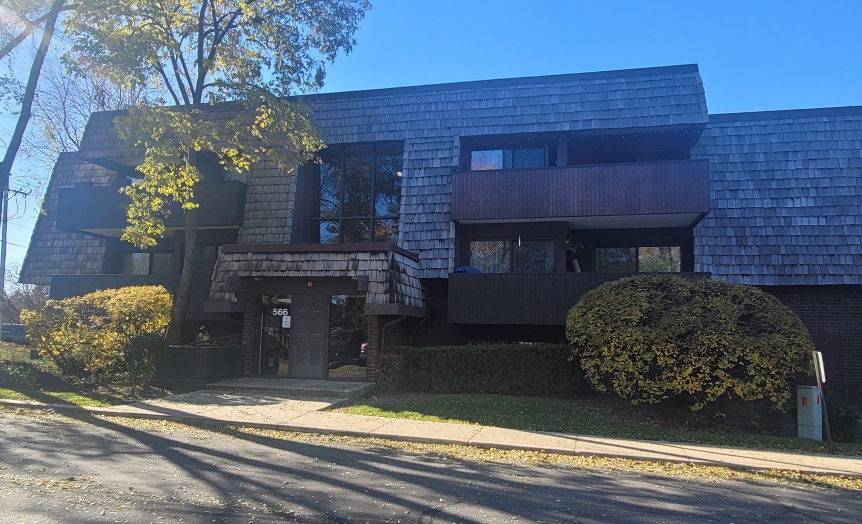566 Timber Ridge Drive, Unit 203 Carol Stream, IL 60188 - Photo 1 of 17 a front view of a house with a yard