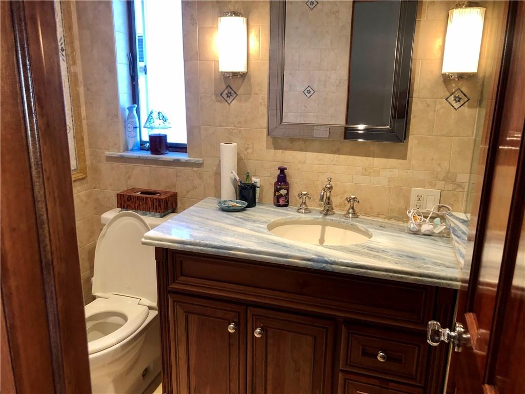 1933 Hendrickson Street Brooklyn, NY 11234 - Photo 15 of 17 a bathroom with a granite countertop sink and a mirror